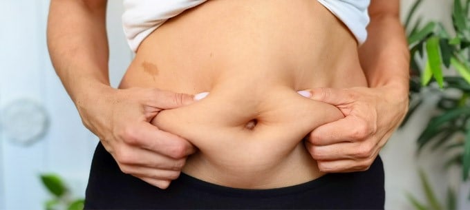 On obese person holds their stomach