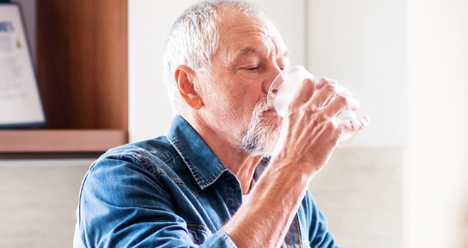 A man drinks a glass of water