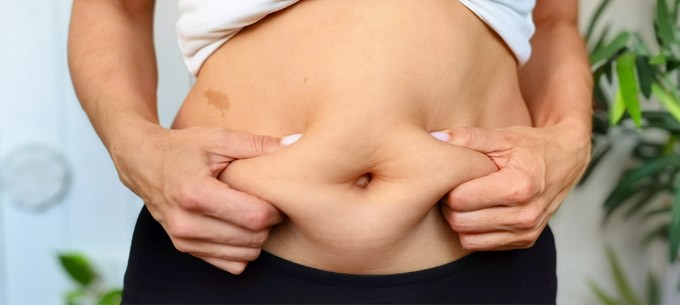 On obese person holds their stomach
