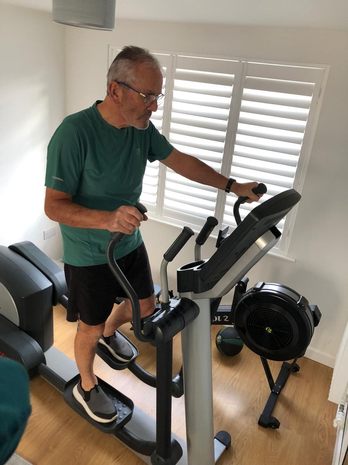 Christopher Willey exercising on a cross trainer after heart treatment