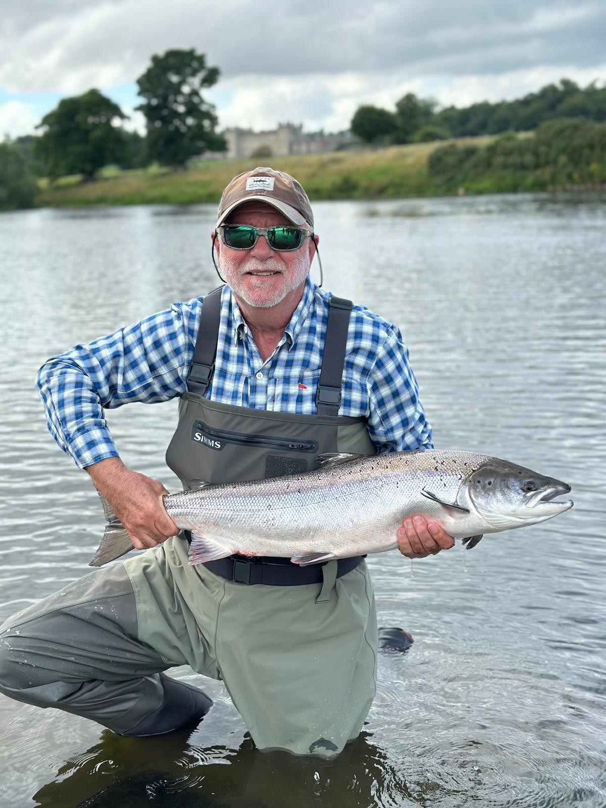 Peter holding a salmon while fishing following open-heart surgery at Spire Nottingham Hospital.