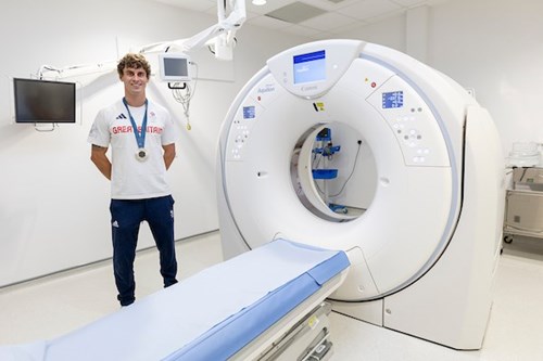 Adam Burgess stood next to the MRI machine